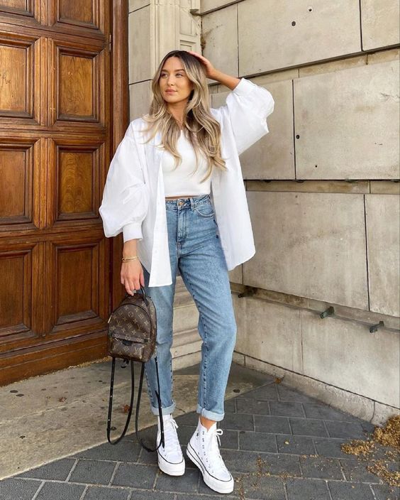 Damska stylizacja z białą koszulą jeansami i trampkami